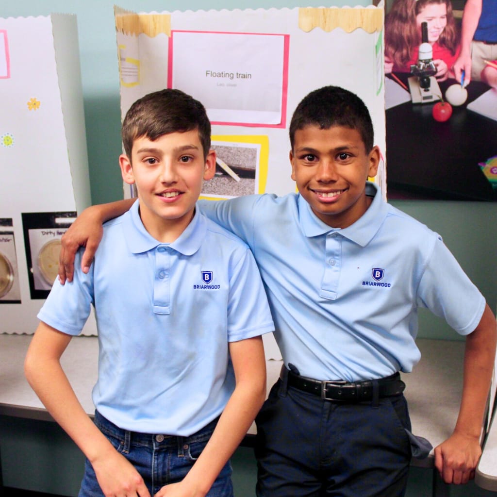 Two Briarwood students smile with their arms around each other.