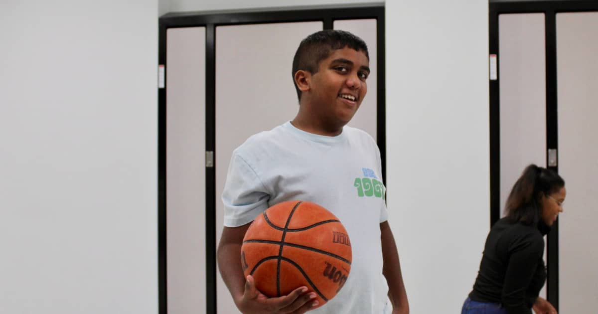 Tuttle elementary student smiles and holds a basketball.