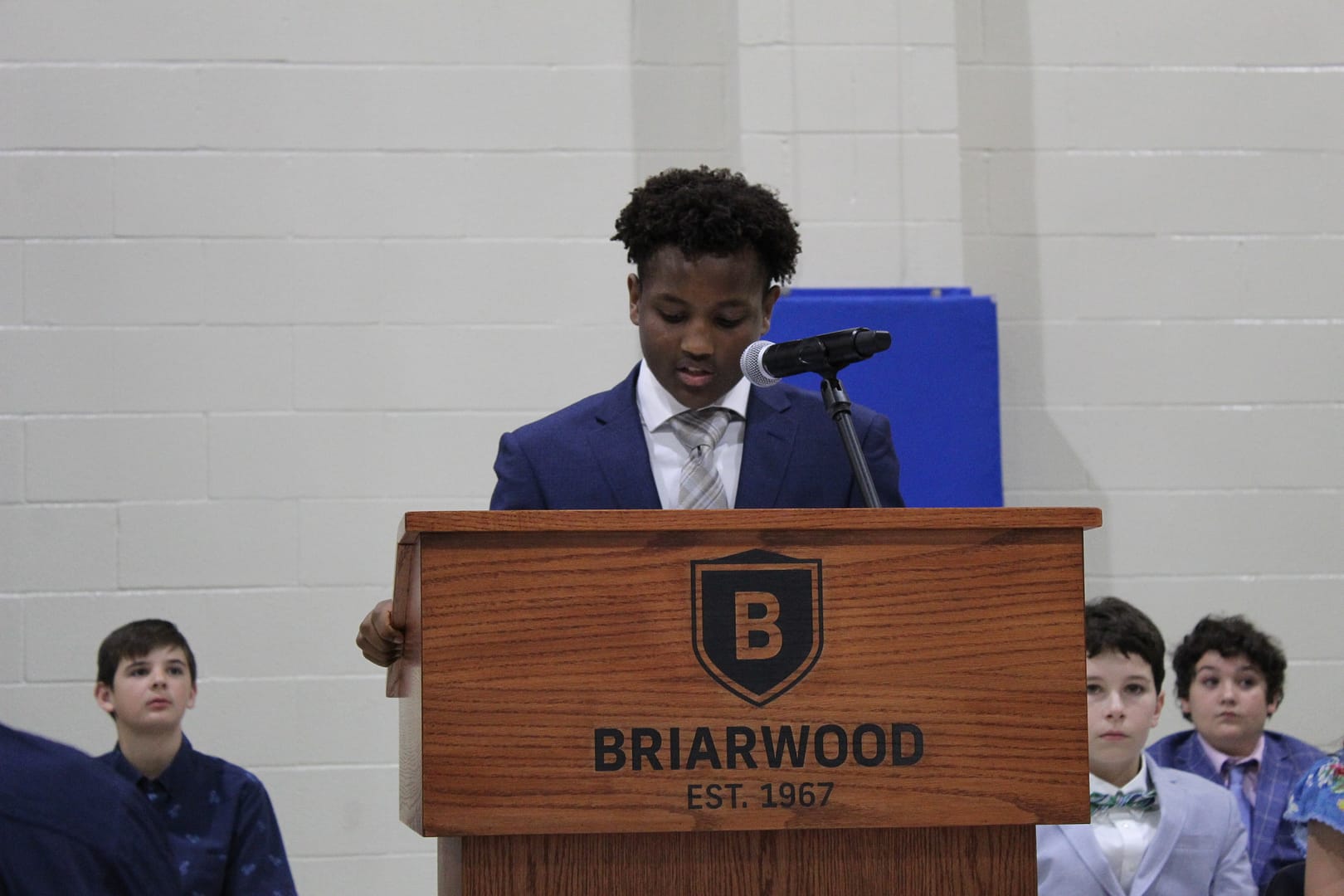 Student stands and speaks at a podium.